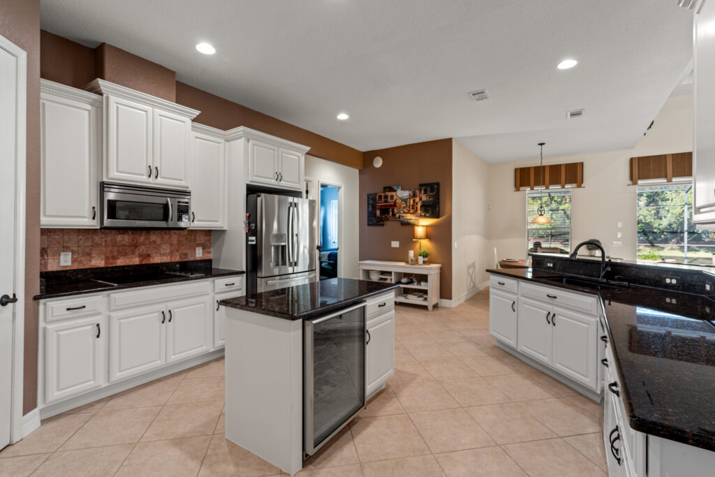 Kitchen with white cabinets, stainless steel appliances, and a central island.
