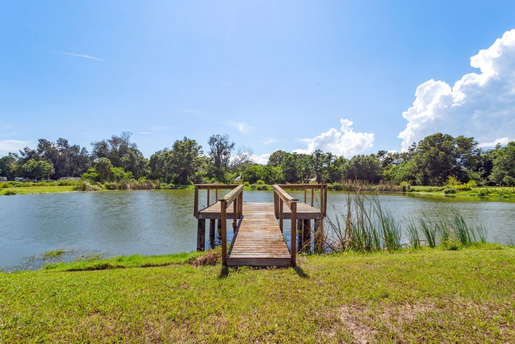 A relaxing dock overlooking a local lake in the backyard of a home in Land O' Lakes, Florida